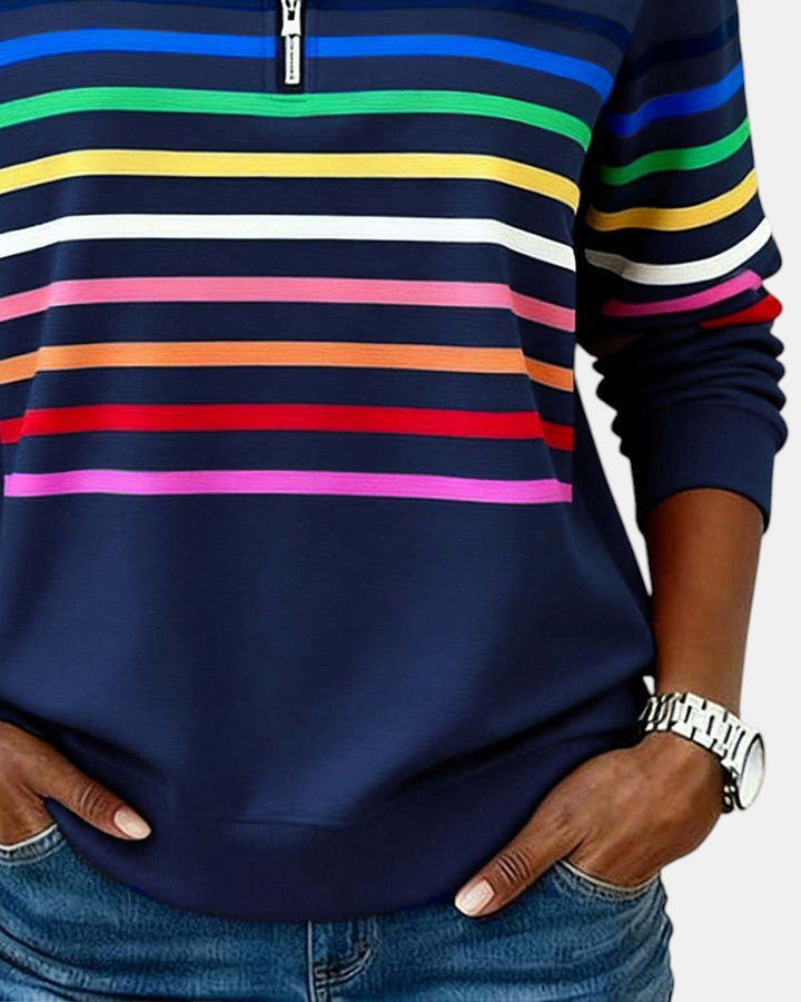 Sweater Margaret Dublin azul-marinho com riscas horizontais coloridas, gola alta com fecho e ajuste relaxado.