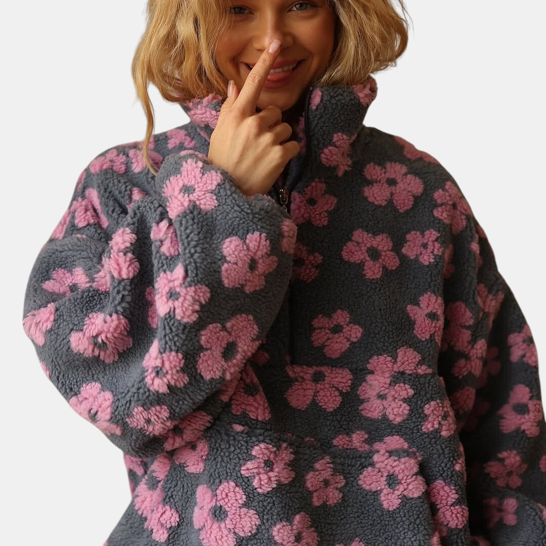 Mulher sorridente veste casaco Margaret Dublin de fleece sherpa cinzento com padrão floral rosa estilo boho