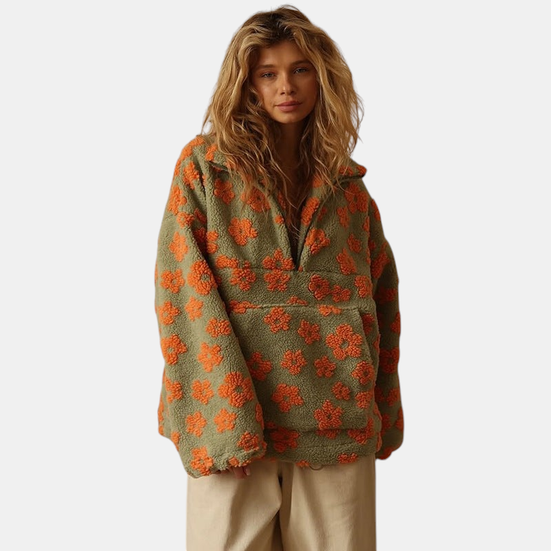 Modelo veste casaco Margaret Dublin Daisy de sherpa verde com padrão floral laranja, corte oversized e fecho frontal