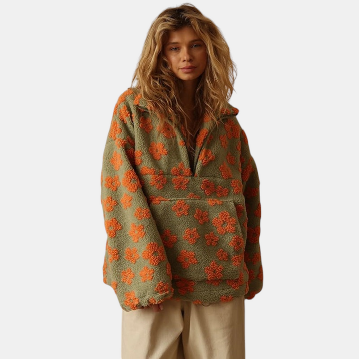 Modelo veste casaco Margaret Dublin Daisy de sherpa verde com padrão floral laranja, corte oversized e fecho frontal
