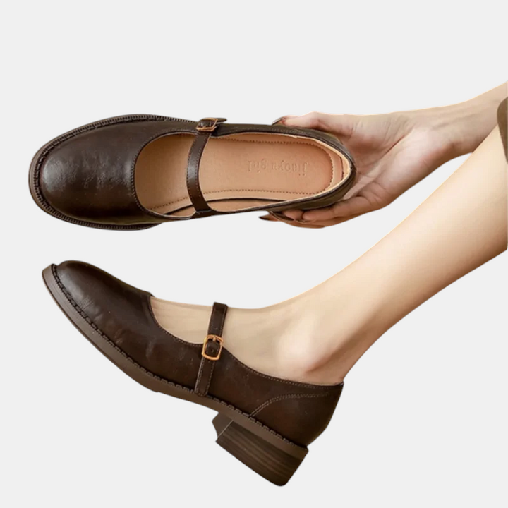Sapatos Leni da Margaret Dublin em castanho escuro com tira e fivela, design clássico e salto médio elegante.