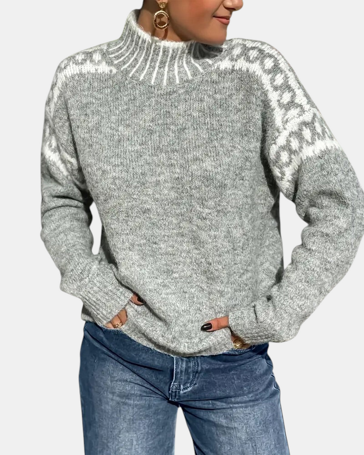 Margaret Dublin grey knit jumper with high neck and Nordic-pattern shoulders, styled with denim trousers.