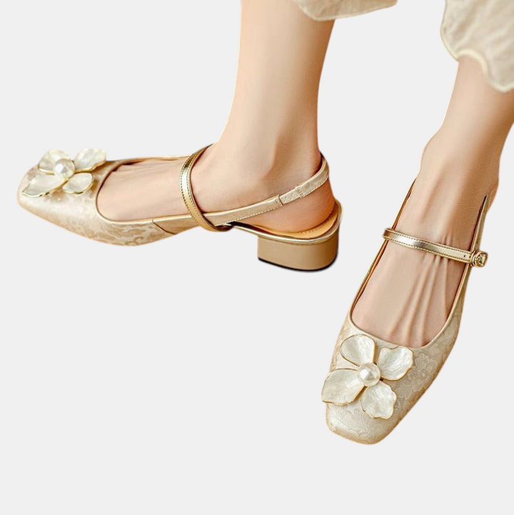 Sapatos femininos Margaret Dublin bege com detalhe de flor e pérola, salto médio e tira elegante no tornozelo.